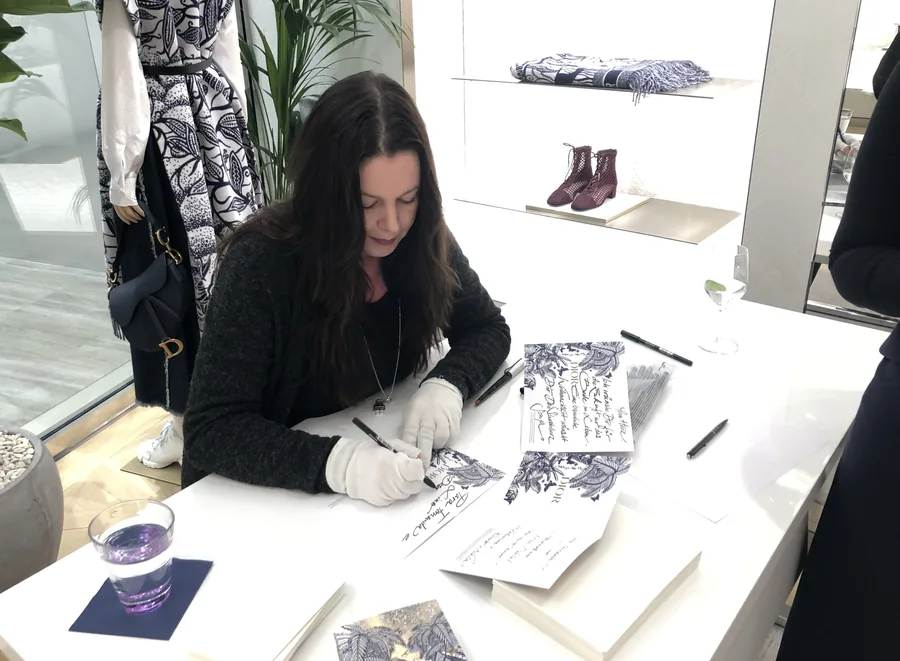 Michaela Al-Badri beschriftet Karten an einem Tisch in einer Boutique